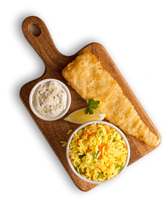 Golden battered fish fillet served with savoury yellow rice, tartar sauce, and a lemon wedge on a wooden board.
