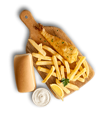 Crispy batter-fried fish filet with french fries, a lemon wedge, white dipping sauce, and a mini loaf on a wooden board.