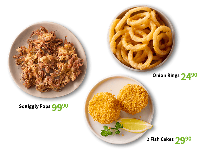 Crispy fried baby squid, a bowl of golden onion rings, and fish cakes with a lemon wedge and parsley.