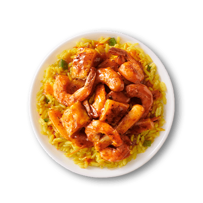Glazed shrimp and fish tossed in savory sauce served over seasoned yellow rice in a white bowl.